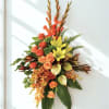 Tall floral arrangement with orange roses and yellow lilies