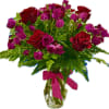 Red roses and pink spray roses in a glass vase with a ribbon