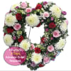 Heart-shaped floral wreath with pink roses, white mums, and red carnations