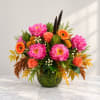 Bright mixed bouquet in a glass vase with pink blooms and orange flowers
