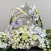 White orchid and rose floral arrangement in a woven basket