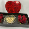 Red roses and chocolates arranged in a black gift box with a heart lid
