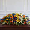 Large multicolored floral casket spray with roses and lilies
