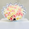 Round bouquet of cream and soft pink roses wrapped in layered white paper with black trim