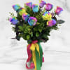 Bouquet of rainbow-colored roses in a glass vase with multicolor ribbons