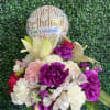 Birthday balloon above a mixed bouquet in a glass vase