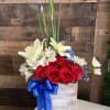Red roses and white lilies in a wooden box with a blue ribbon