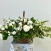 White roses and snapdragons in a woven basket