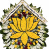 Large floral wreath with yellow and red roses and white flowers, framed by two memorial ribbons.