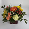 Summer Sunrise is designed in a red vase with summer-y hot florals.