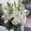 White lily and rose bouquet in a clear glass vase