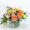 Mixed bouquet of pink and orange roses in a clear glass vase