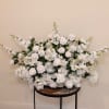 Large white floral arrangement with roses and blossoms on a round table