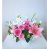 Pink and white floral arrangement in a white vase with lilies and roses