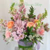 A full, rounded mix of chrysanthemums, carnations, ranunculus, alstroemeria and small filler