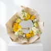 Yellow and white flower bouquet wrapped around a round mirror