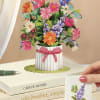 Pop-up bouquet card with colorful flowers and butterflies in a striped vase