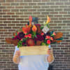 Mixed floral arrangement in a wooden box with orange calla lilies and deep red blooms