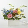 Mixed bouquet in a white box with yellow roses, pink carnations, and white daisies