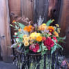 A lovely collection of fall flowers,  pumpkins, branches and dried good