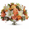 Peach roses and white lilies in a silver pedestal vase