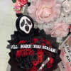 Black bouquet with red roses and a Ghostface plush topper