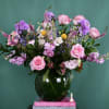 Pink and purple mixed bouquet in a dark glass vase