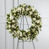White floral wreath on a black stand