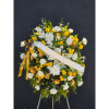 Large white and yellow floral standing spray with a ribbon sash