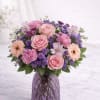 A delicate and elegant arrangement designed with soft blush roses, lavender statice