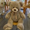 Large plush teddy bear with a plaid ribbon bow