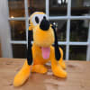 Plush yellow dog with black ears and pink tongue