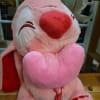 Pink plush teddy bear holding a heart pillow