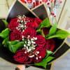 Bouquet of red roses with white baby's breath in black and gold wrap