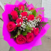 Bouquet of hot pink roses with white filler flowers wrapped in bright pink paper