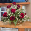 Basket arrangement of red roses and white baby's breath