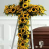 A radiant standing cross of sunflowers, daisies and chrysanthemums designed as a