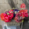 Basket arrangement with pink anthuriums, peonies, and roses
