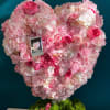 Heart-shaped pink floral arrangement in a box with a ribbon