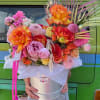 Large mixed bouquet in a silver hatbox with bright orange roses and pink blooms