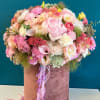 Large pink and peach mixed flower arrangement in a velvet hat box