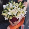 Large bouquet of white lilies held by a person