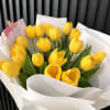 Bouquet of yellow tulips wrapped in white paper
