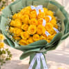 Bouquet of yellow roses with small white daisies wrapped in green paper