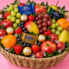 Fruit basket with apples, grapes, strawberries, oranges, pears, and chocolates