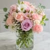 Soft pink roses and lavender accents form a rounded, airy bouquet that