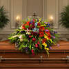 A low, elongated spray awash in a rainbow of blooms-this funeral casket