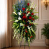 A dignified red, white, and blue funeral spray that conveys respectful remembrance
