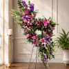 A lush crescent of pink lilies and roses shapes this standing spray