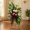 A striking asymmetric spray of red roses and white lilies rises on